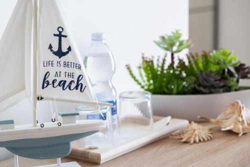 a wooden boat with a sign that reads life is better at the beach at Vele d'Otranto B&B in Otranto