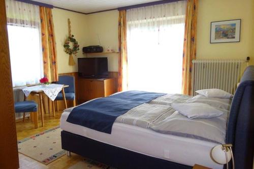 - une chambre avec un lit, une table et des fenêtres dans l'établissement Apartments by Haus Ingrid, à Kötschach-Mauthen