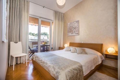 een slaapkamer met een bed en een groot raam bij Apartman Dora in Poreč