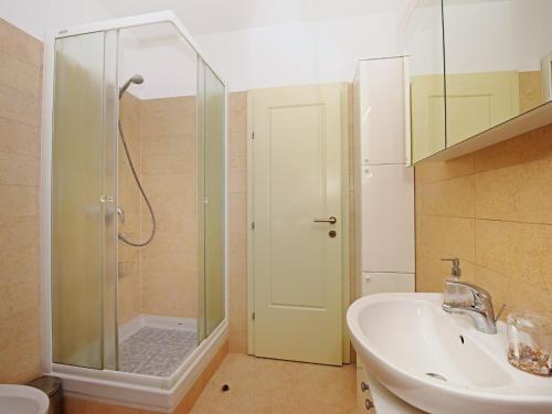 een badkamer met een douche, een wastafel en een toilet bij Apartman Dora in Poreč