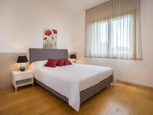 een slaapkamer met een groot wit bed met rode kussens bij MAJ - ANA - Luxury Family Apartments with Pool in Poreč