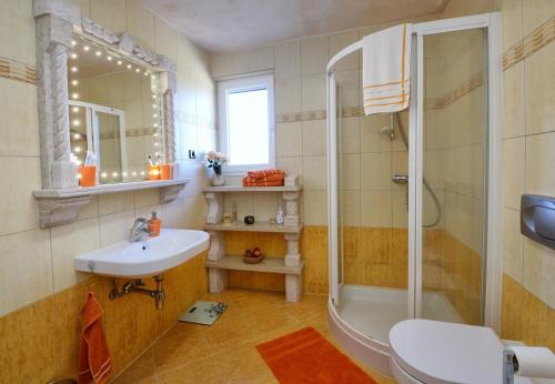 a bathroom with a sink and a shower and a toilet at Villa Bianca in Tar