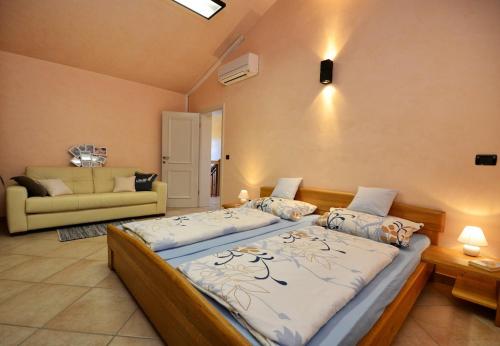 a bedroom with two beds and a couch at Villa Bianca in Tar