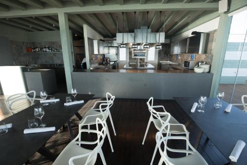 a kitchen with a table and four white stools at Luna Minoica Suites and Apartments in Montallegro