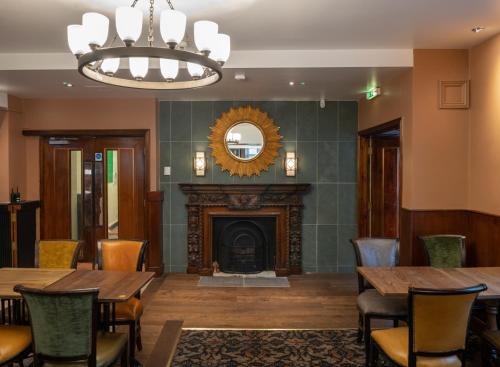 a dining room with a fireplace and a table and chairs at The Kings Head Inn Wetherspoon in Salisbury