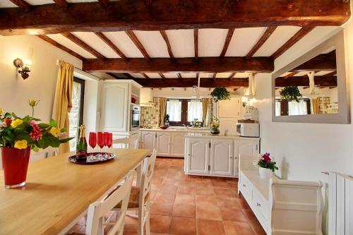 eine Küche mit weißen Schränken und einem Holztisch in der Unterkunft Maison de 2 chambres avec jardin clos et wifi a Plehedel a 5 km de la plage in Pléhédel