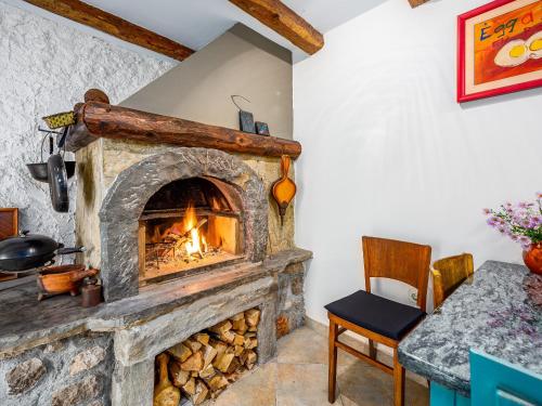 a stone fireplace in a room with a table at Holiday home Dane 22 Ucka in Buzet