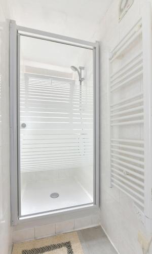 une douche avec une porte vitrée dans une salle de bain dans l'établissement Appart Hôtel Sens hypercentre, à Sens