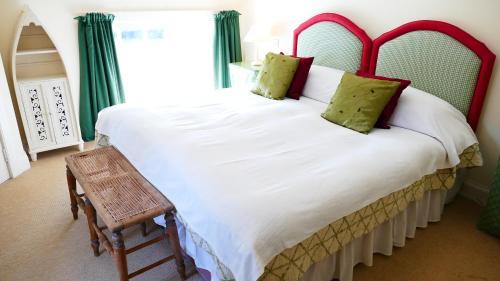 a bedroom with a large white bed with green curtains at Arndean Cottages in Dollar