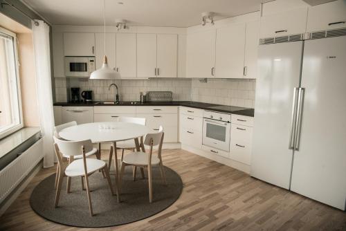 a kitchen with a table and chairs and a refrigerator at Sky Hotel Apartments Valla Berså in Linköping