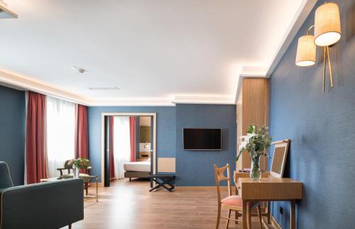 a hotel room with a dining table and a living room at Principe Pio in Madrid