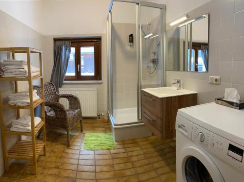 a bathroom with a shower and a washing machine at Apartment Sophia - Hallstatt in Hallstatt