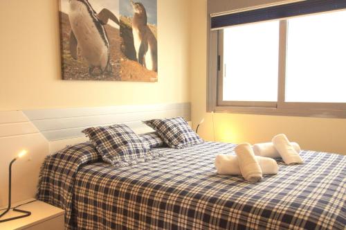 a bedroom with a bed with two pillows and penguins at Spanish Connection - Las Drizas in Cabo de Palos
