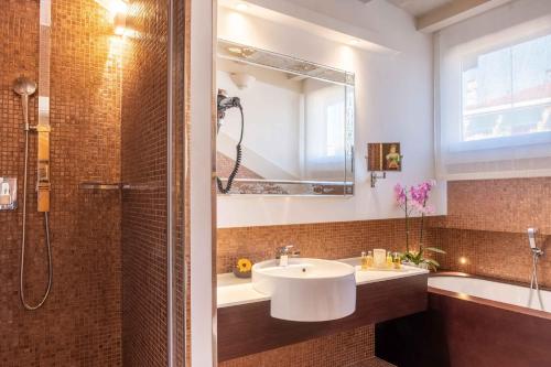 a bathroom with a sink and a shower and a tub at Hotel Moresco in Venice