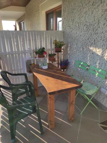 a wooden table and a green chair on a patio at Agroturystyka Kobylnica nad Wisłą in Kobylnica