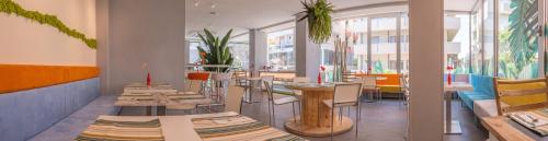 um restaurante com mesas e cadeiras num quarto em Design Hotel Astra B&B em Misano Adriatico