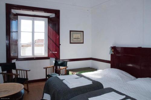 a bedroom with a bed and a table and a window at Casa do Sertório - Casa inteira in Évora