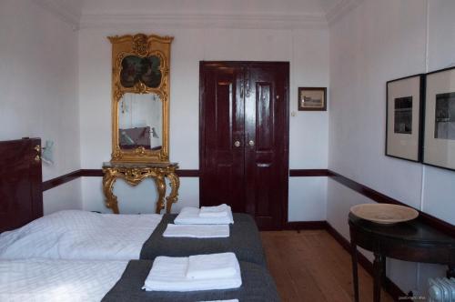 a bedroom with a bed and a mirror on the wall at Casa do Sertório - Casa inteira in Évora