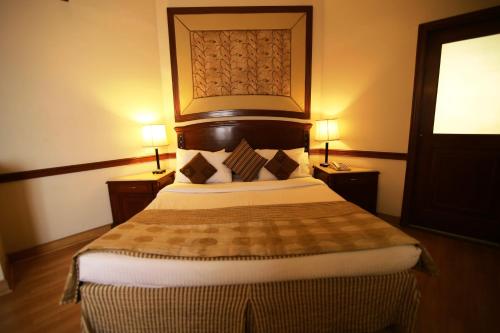 a bedroom with a large bed with two lamps at Hotel President in Jalandhar