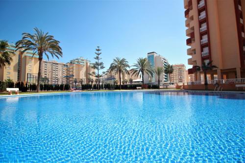 una gran piscina con palmeras y edificios en Spanish Connection - Los Miradores del Puerto, en La Manga del Mar Menor