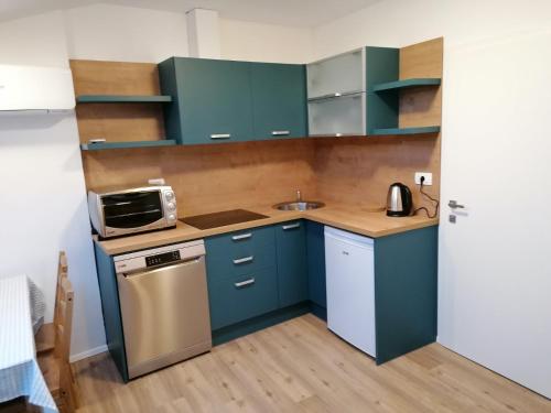 a small kitchen with blue cabinets and a sink at Apartments Gina in Piran