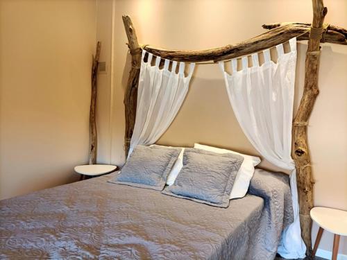 une chambre avec un lit à baldaquin avec des rideaux blancs dans l'établissement Charmante Maison à 200 mètres de la Plage, Saint-Pierre-La-Mer 10INAV5, à Saint Pierre La Mer