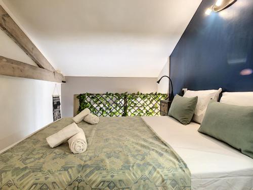 une chambre avec un grand lit avec des oreillers dessus dans l'établissement Nestor&Jeeves - SECRET BEACH DUPLEX - Very close sea - Atypical, à Nice