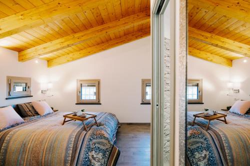 two beds in a room with wooden ceilings at Charming House in Amalfi