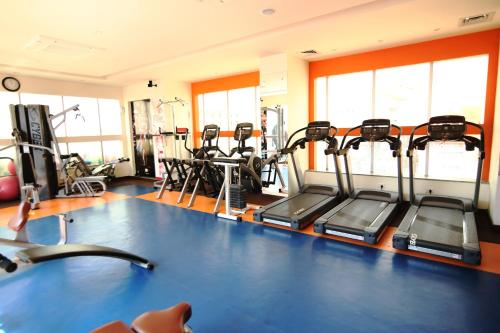 a gym with several treadmills and elliptical machines at Hotel President in Jalandhar
