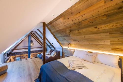 a bed in a room with a wooden ceiling at Weinstöckl Hochgrail pures sein in Sankt Stefan ob Stainz