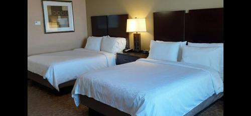two beds in a hotel room with white sheets at Eagle NestInn in Pecos