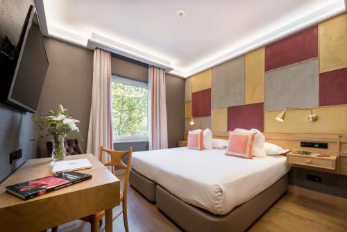 a hotel room with a bed and a desk at Principe Pio in Madrid