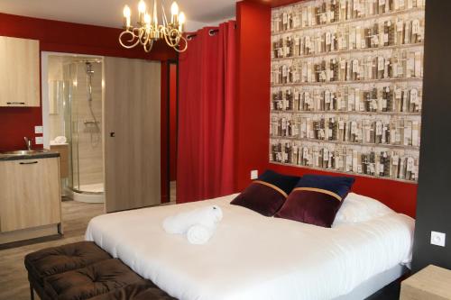 a bedroom with a large white bed with red walls at R'Studio Ciné Salle 2 Hypercentre Grenoble in Grenoble