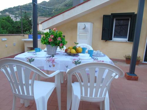a white table with fruit and flowers on it at Stella Maris Holidays in Maiori