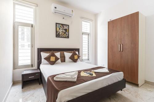 a bedroom with a large bed with a wooden cabinet at BluO 1BHK Koramangala - Terrace Garden, Parking in Bangalore