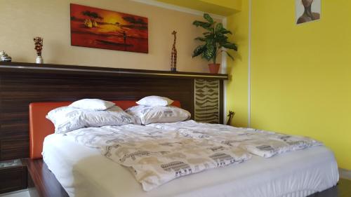 ハイドゥソボスローにあるSafari Apartmanのベッド(白いシーツ、枕付)