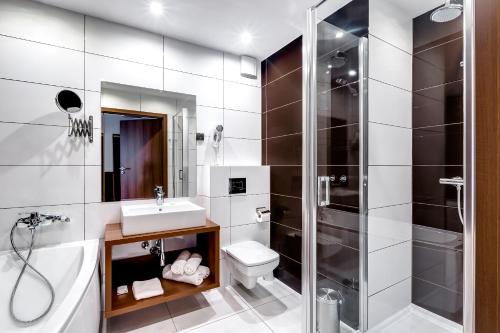 a bathroom with a shower and a toilet and a sink at Hotel Konradówka Wellness & SPA - 300 metrów do centrum in Karpacz