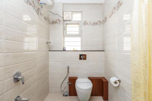 a bathroom with a toilet and a window at BluO 1BHK Koramangala - Terrace Garden, Parking in Bangalore