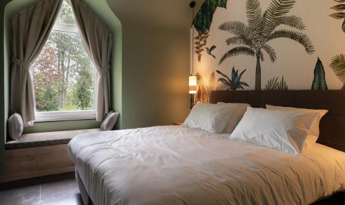 a bedroom with a large bed and a window at La Villa du Hautsart in Jodoigne