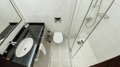 a bathroom with a toilet and a sink and a shower at Resident City Hotel in Almaty