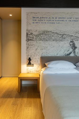 a bedroom with a white bed and a table at One Suite Hotel in Mlini