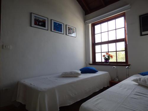 deux lits dans une chambre avec une fenêtre dans l'établissement Finca La Paz, à Puntagorda