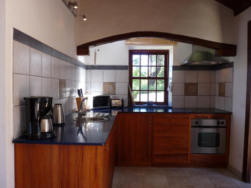 une cuisine avec des armoires en bois et un comptoir dans l'établissement Finca La Paz, à Puntagorda