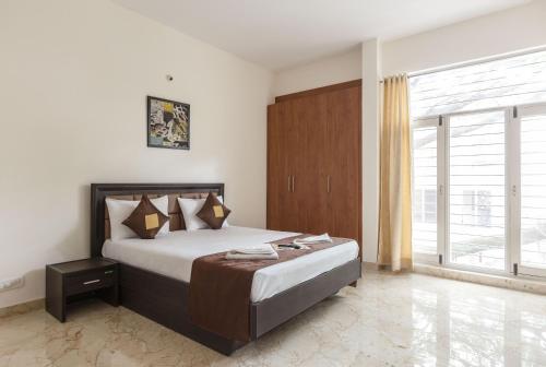 a bedroom with a bed and a large window at BluO Studio Koramangala - Terrace Garden, Parking in Bengaluru