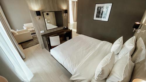 a bedroom with a white bed and a mirror at Resident City Hotel in Almaty