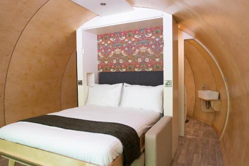 ダウンパトリックにあるKinelarty Luxury Glamping Pods Downpatrickのアーチのある小さな部屋のベッド1台分です。