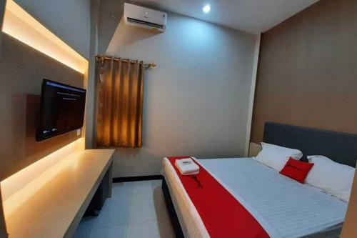 a small bedroom with a bed and a television at RedDoorz near Universitas Muhammadiyah Purwokerto in Kembaran