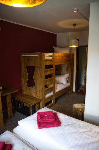 a bedroom with a bunk bed with a red bag on it at Berghotel Bärenstein in Bärenstein