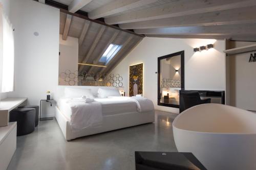 - une chambre blanche avec un lit blanc et un bureau dans l'établissement Agriturismo Redó, à Ponti sul Mincio