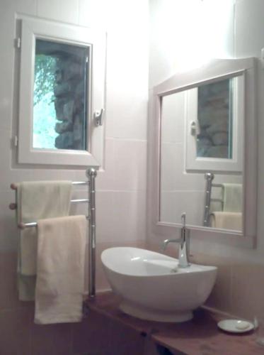 une salle de bain avec un lavabo blanc et un miroir dans l'établissement Charmante maison avec piscine partagée à Le Buisson-de-Cadouin, au Buisson de Cadouin
